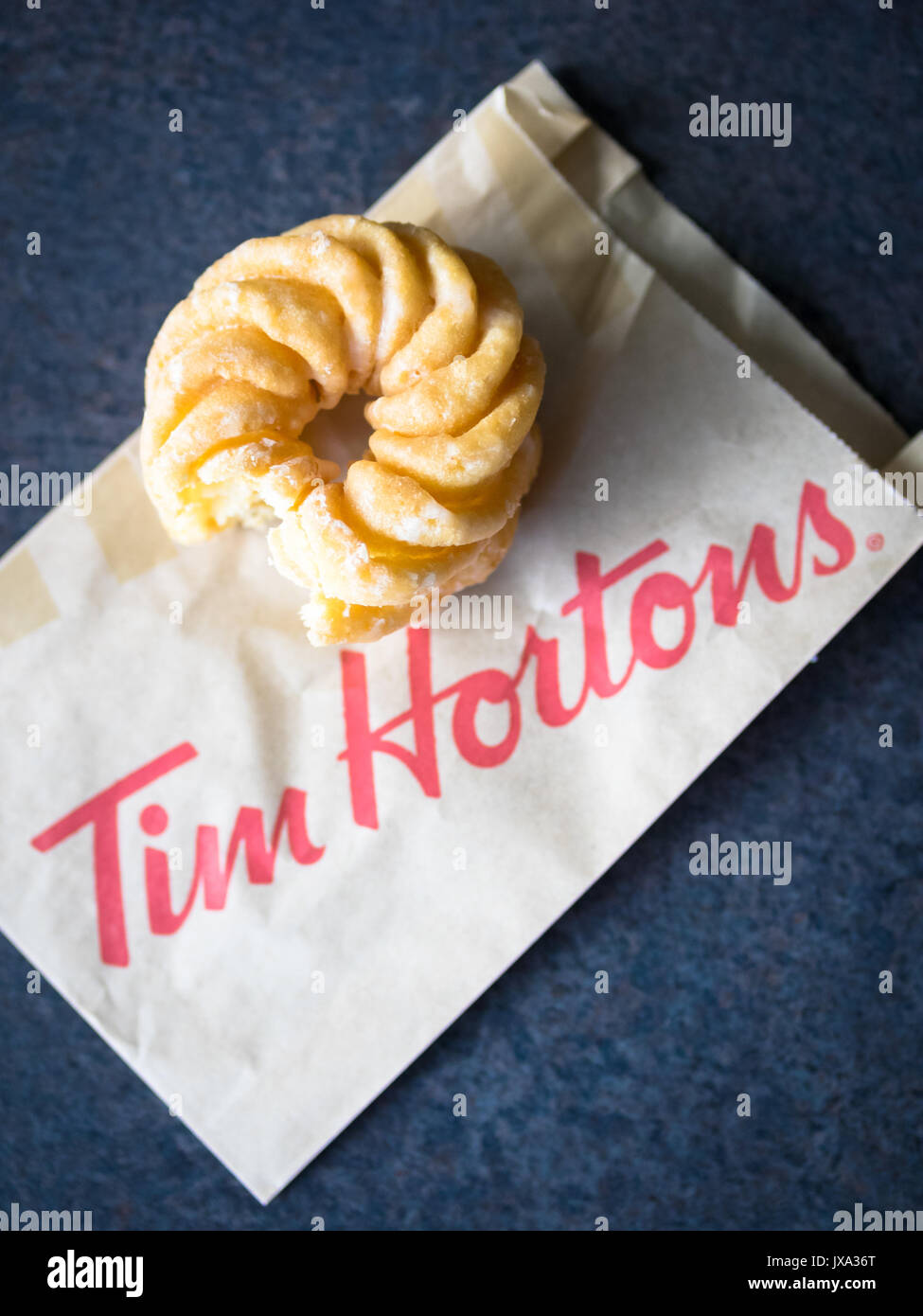 Un miele cruller donut da Tim Hortons, un popolare Canadian fast food ristorante e negozio donut. Foto Stock
