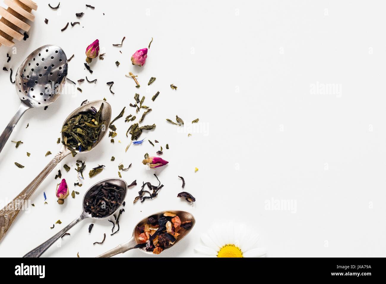 Varietà di tè essiccate, erbe essiccate, verde, tè nero e tè di frutta su vintage argenteria cucchiaini da tè su sfondo bianco con copia spazio spa negativa Foto Stock