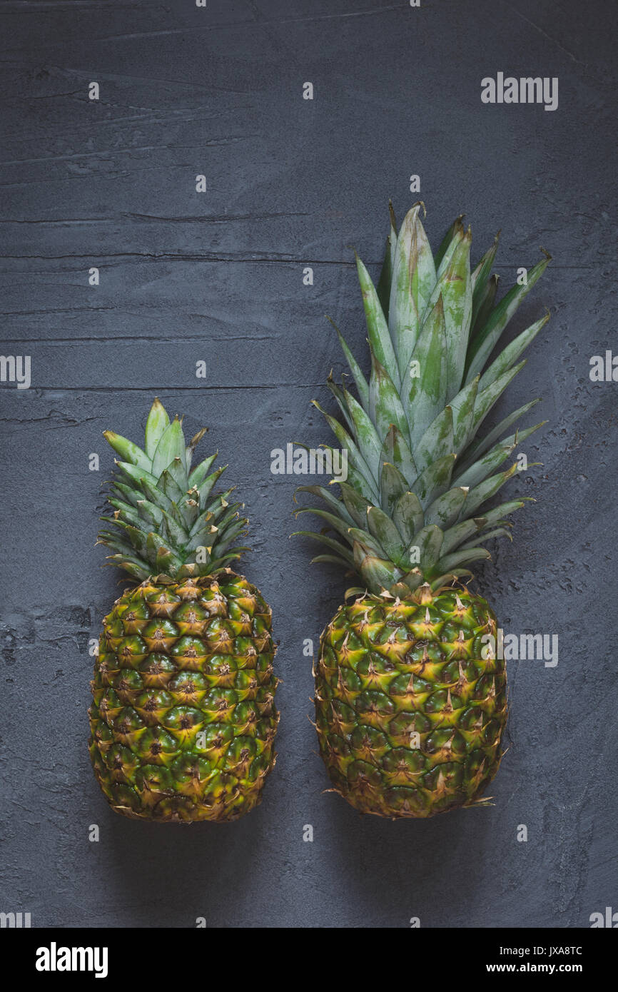 Due ananas su sfondo scuro. Vista dall'alto uno spazio di copia Foto Stock