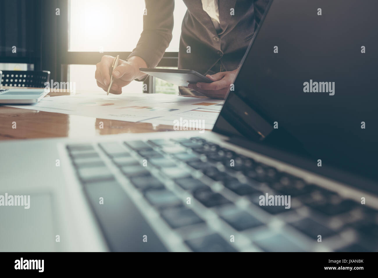 Imprenditore utilizzando tablet e computer portatile per lavorare con i dati finanziari Foto Stock