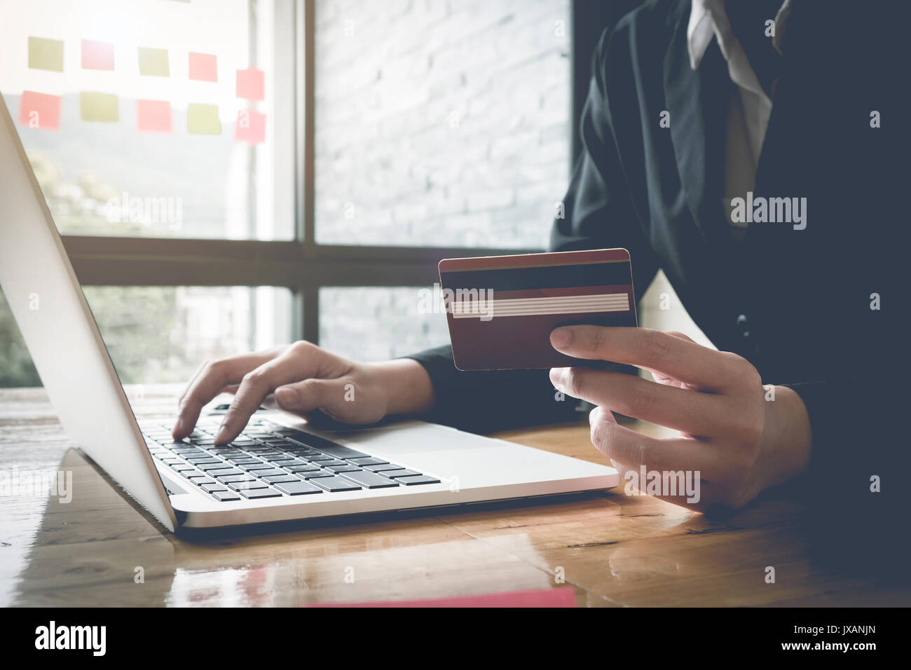 Pagamento Online,Business donna con le mani in mano in possesso di una carta di credito e utilizzo di computer portatile per lo shopping online con vintage tono del filtro Foto Stock