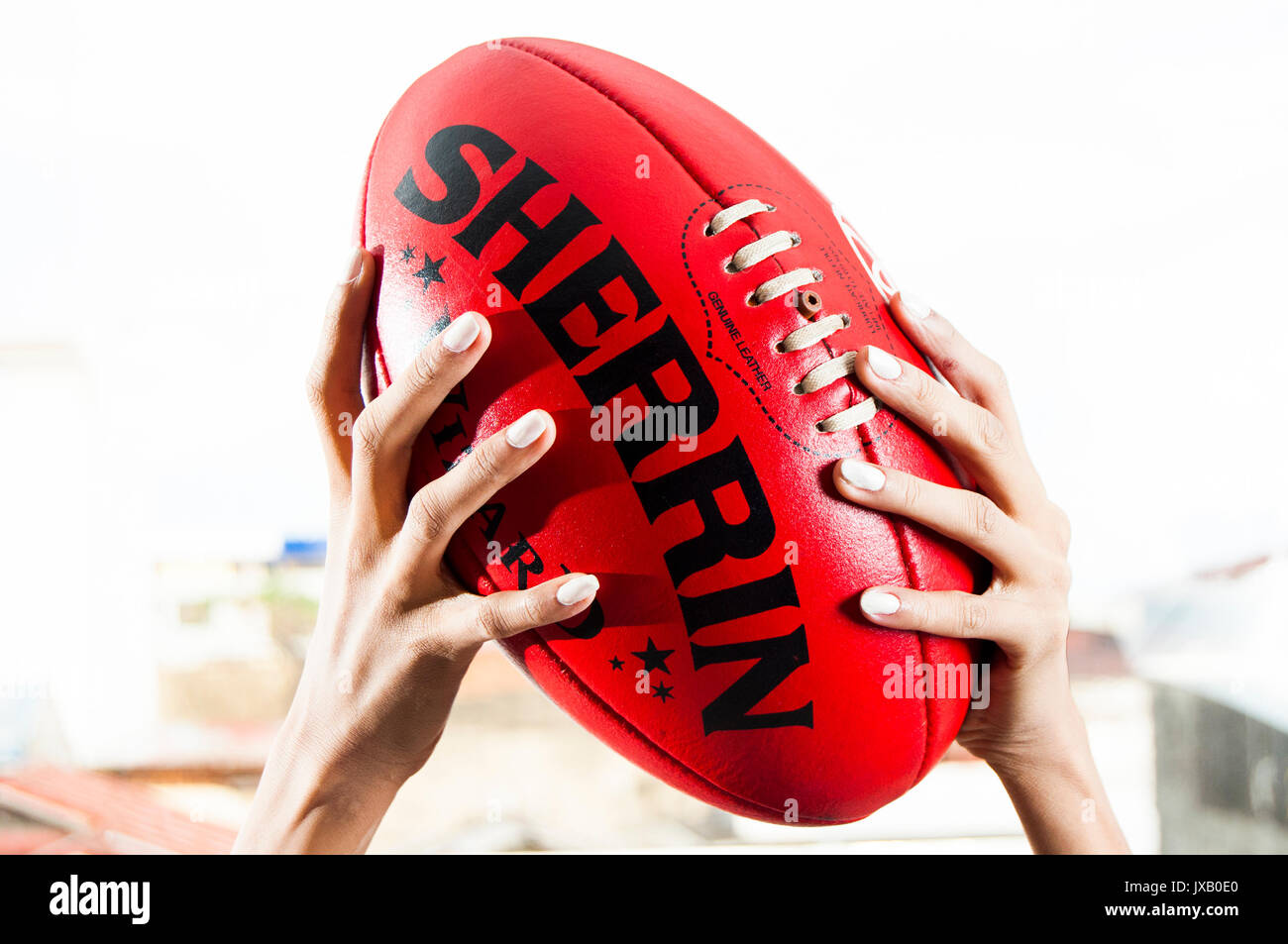 Donna con le mani in mano azienda australiana o AFL Football Foto Stock