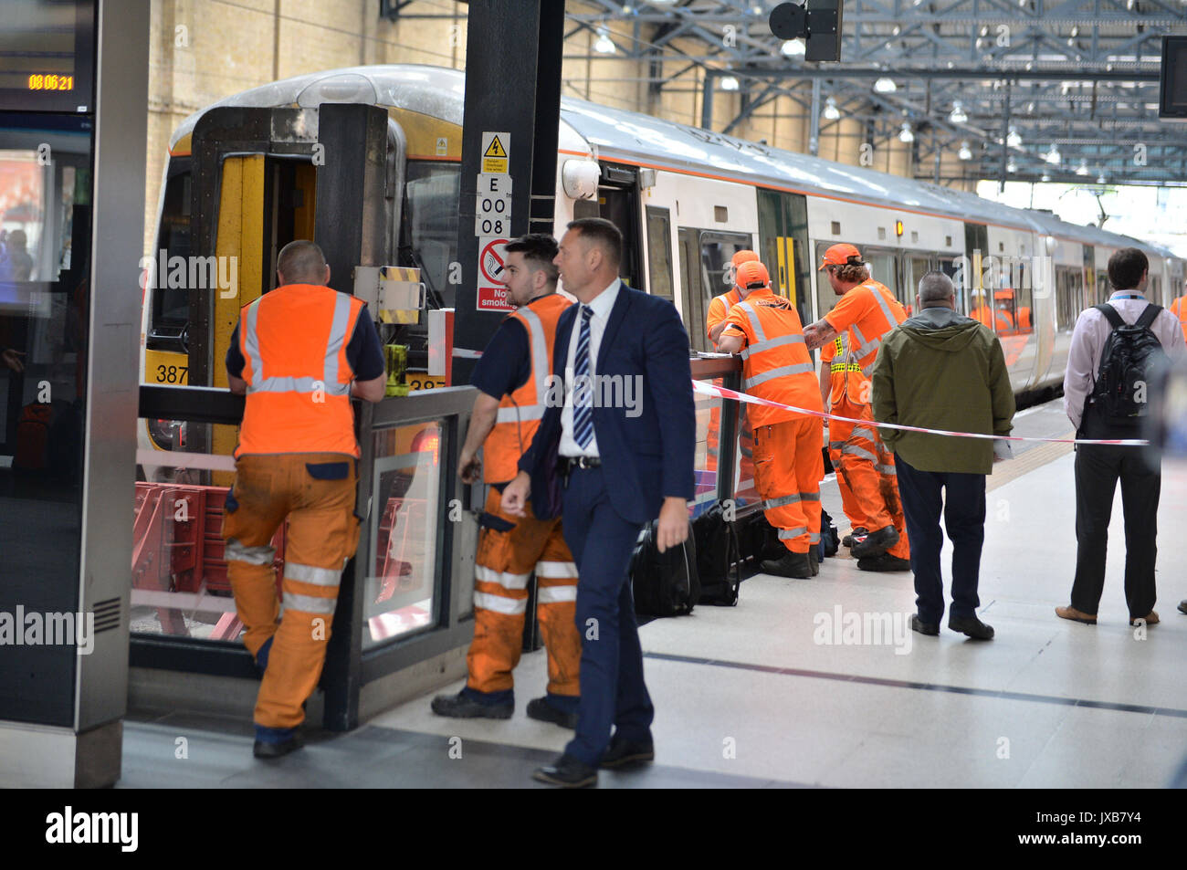Il personale delle ferrovie a Londra la stazione di King Cross guardare un treno da Royston che sembrava che hanno colpito i buffer in corrispondenza della piattaforma 9. Foto Stock