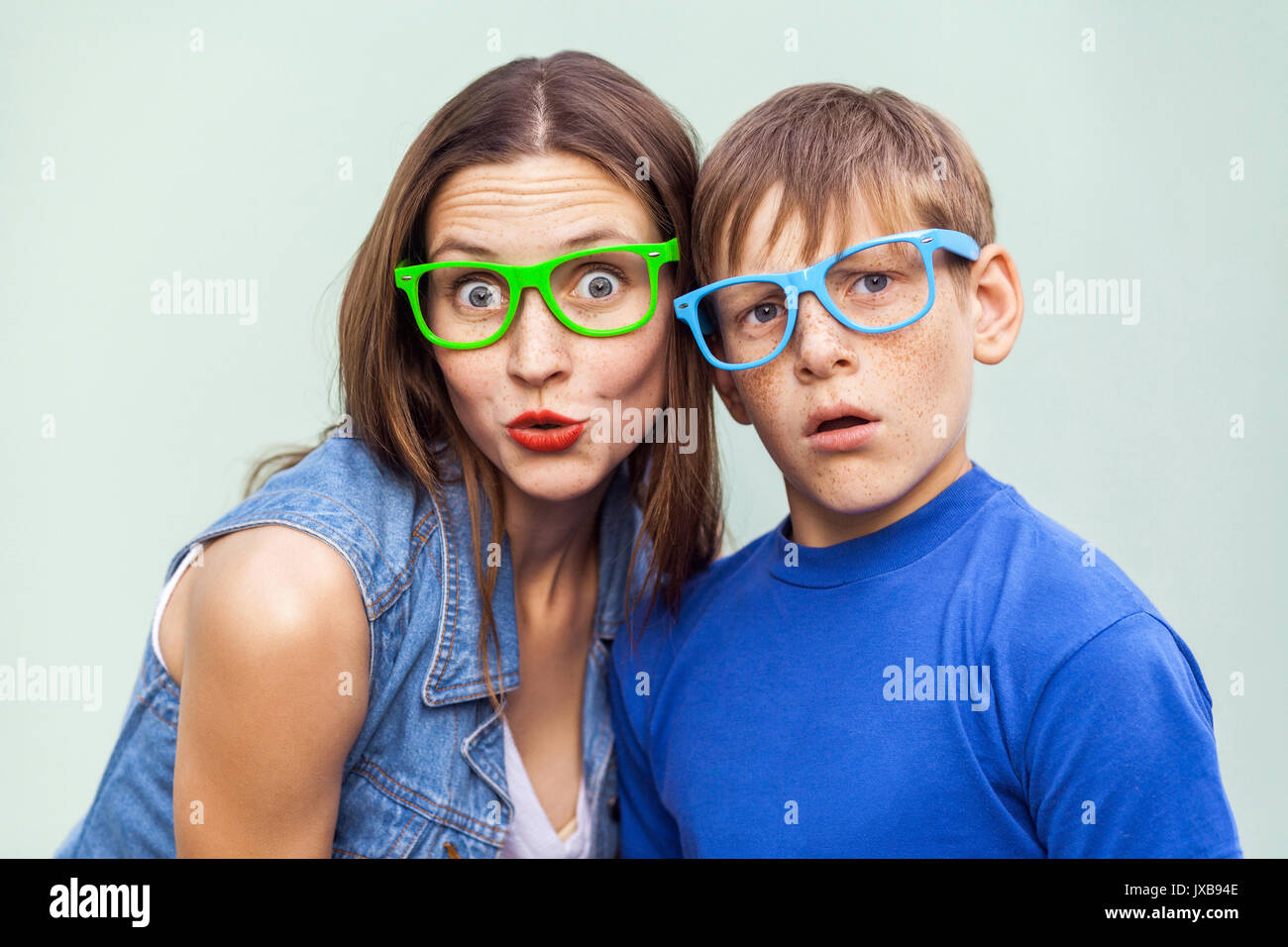 Famiglia, emozioni e sentimenti. Sorella e suo fratello con lentiggini, ponendo su fondo azzurro insieme sul tempo estivo, guardando camer Foto Stock