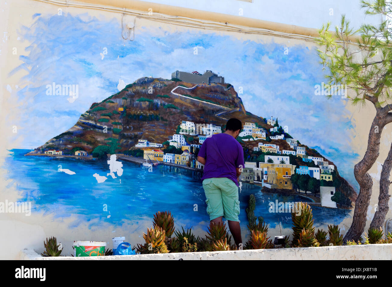 Uomo che ripara murale di Aghia Marina e Castello di Panteli, Lakki, LEROS, DODECANNESO isole, Grecia. Foto Stock