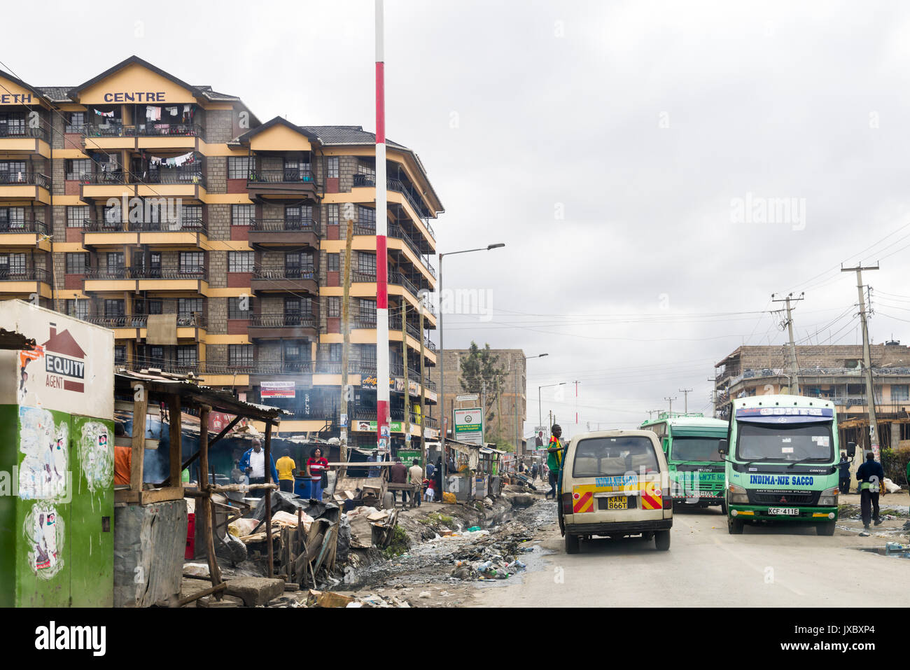Matatu mini bus e altri bus la guida su una strada di città di Nairobi, in Kenya Foto Stock