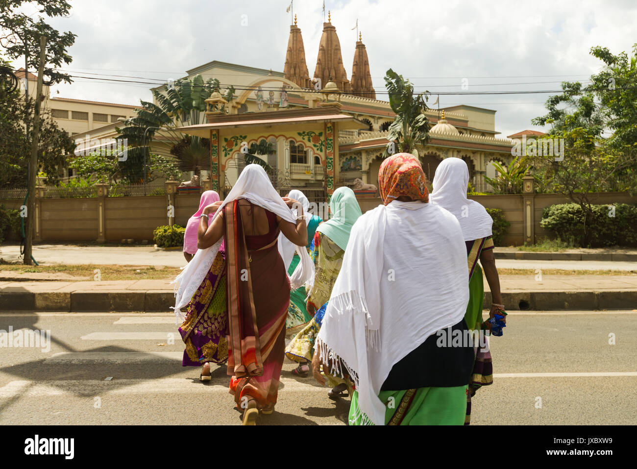 Le donne indiane di indossare il velo islamico e Hindu abbigliamento attraversamento strada andando a Oriente Africa Satsang Swaminarayan tempio, Nairobi, Kenia Foto Stock