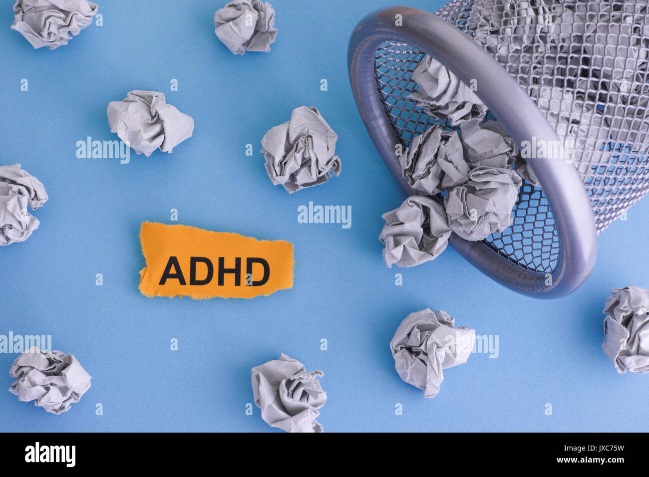 ADHD (Attention Deficit Hyperactivity Disorder). Grigio carta sgualcita sfere che rotolano fuori un cestino. Close up. Concetto di immagine. Foto Stock