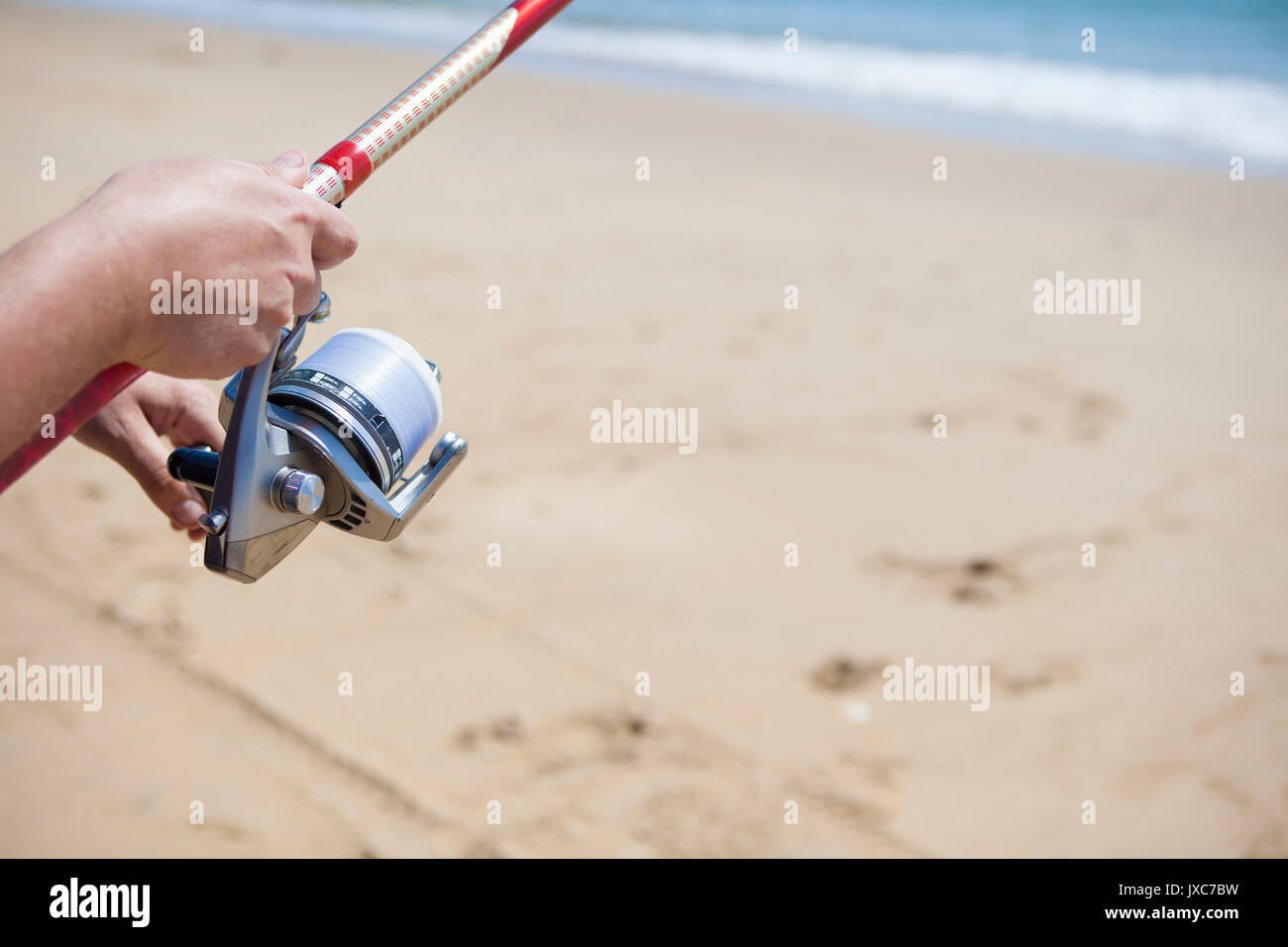 La piegatura della lenza. La pesca con lenza in mare sport in spiaggia Foto Stock