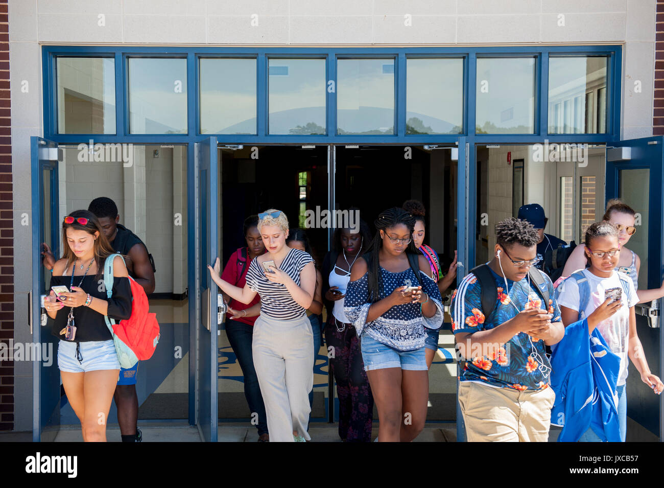 Teens Kids addicted a e fissando i loro telefoni cellulari Foto Stock
