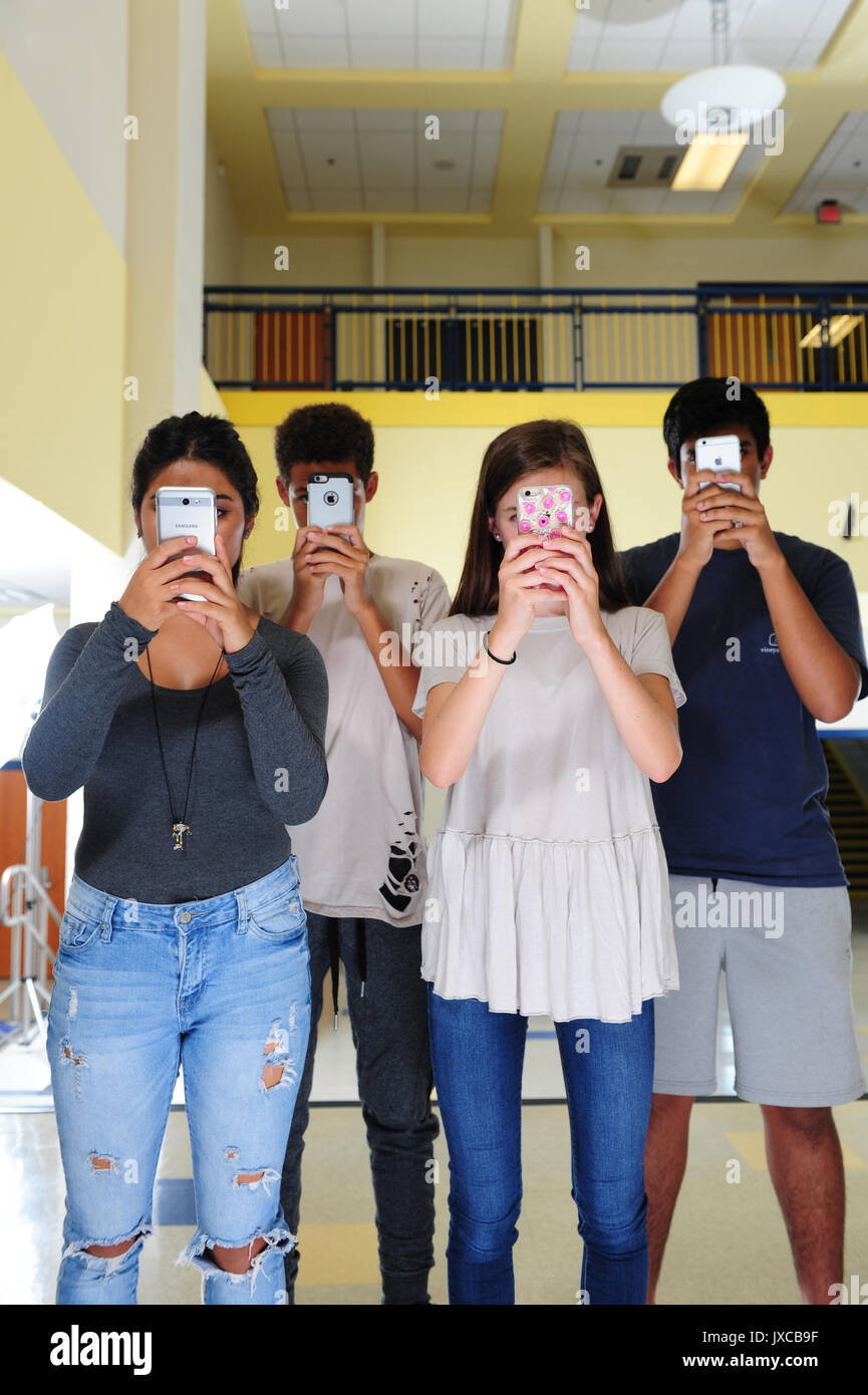 Teens Kids addicted a e fissando i loro telefoni cellulari Foto Stock