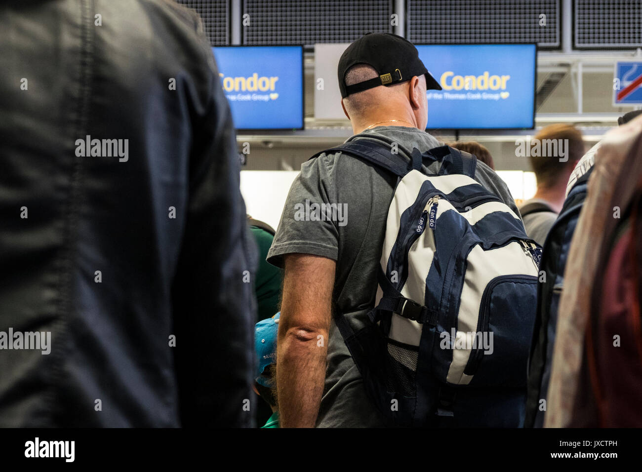 Messa in coda con il bagaglio a mano per il check-in per un volo da Condor, Thomas Cook Airlines da aeroporto di Monaco di Baviera, Germania Foto Stock