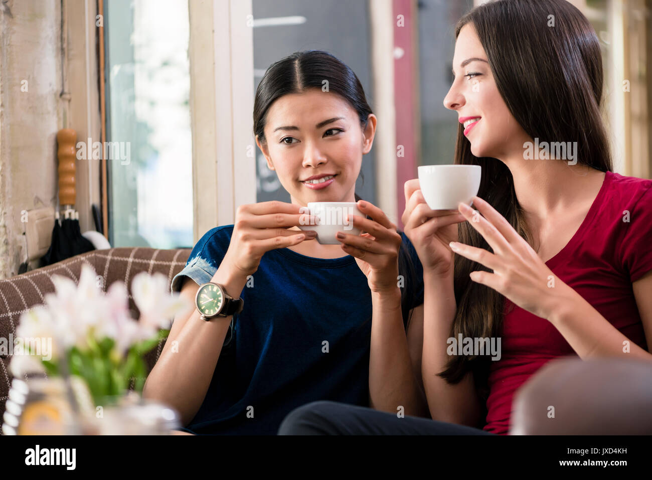 Giovane donna fantasticando bevendo una tazza di caffè Foto Stock