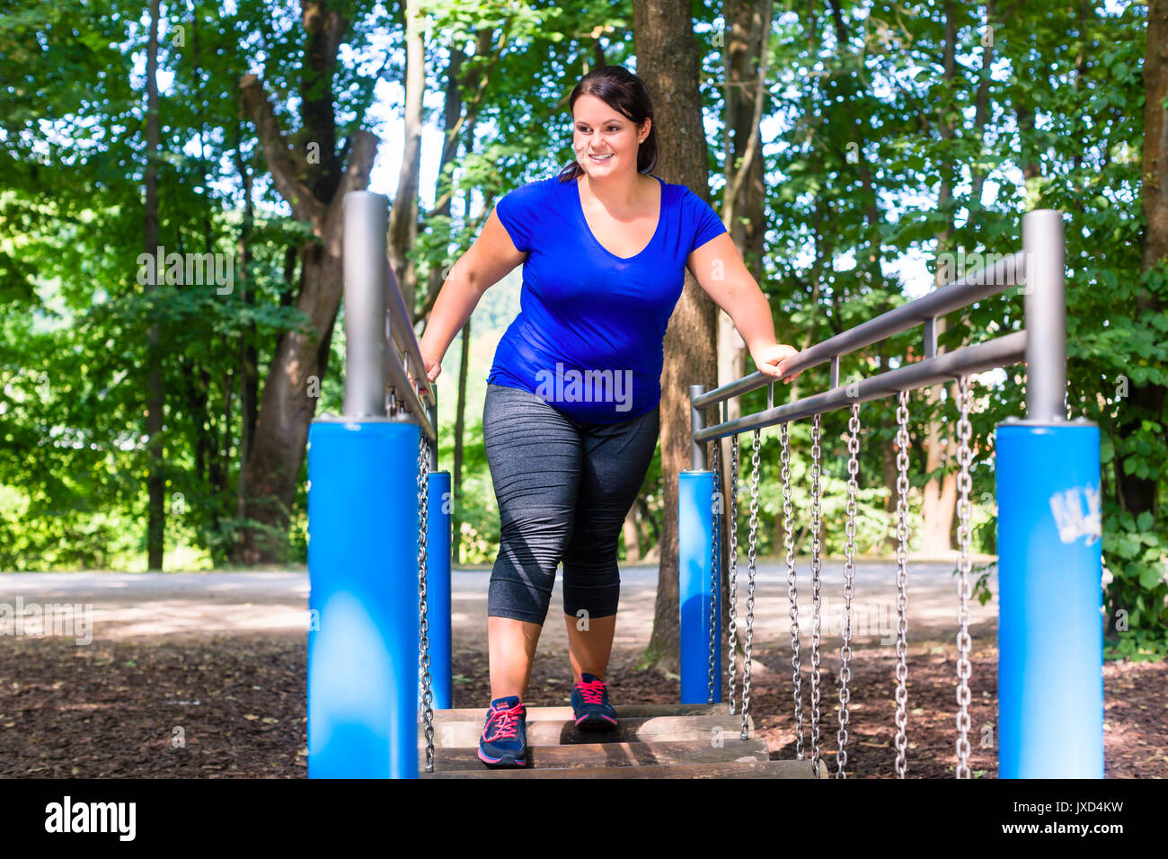 Donna sovrappeso nel Parco di arrampicata fare sport Foto Stock