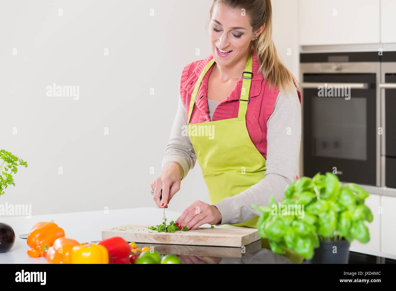 La donna in cucina erbe di taglio Foto Stock