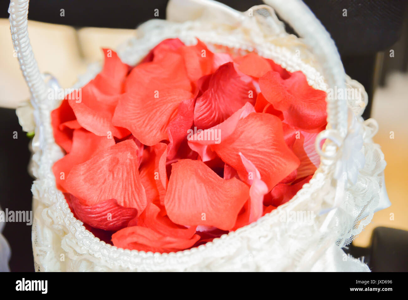 Accessori sposa. Rose rosse all'interno del cesto bianco Foto Stock
