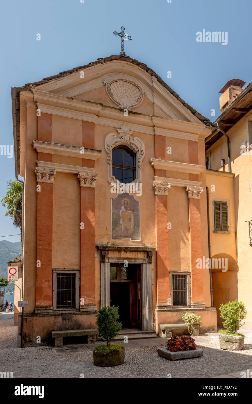 La facciata della vecchia chiesa di San Rocco in storico villaggio turistico, shot sulla luminosa giornata estiva a Orta San Giulio, Novara, Cusio, Italia Foto Stock