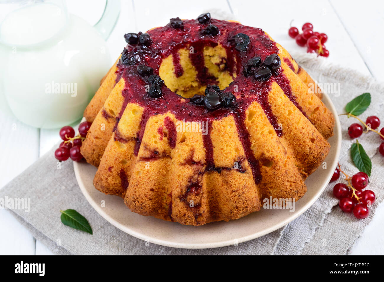 Torte fresche con estate bacche brocca del latte su sfondo bianco Foto Stock