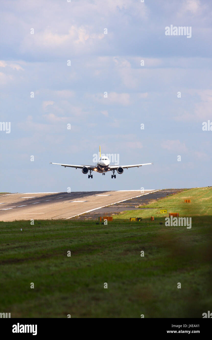 Leeds, Regno Unito. Il 15 agosto, 2017. Regno Unito Meteo. Soleggiato ma blustery a Leeds e Bradford Airport con venti trasversali rendere interessante lo sbarco per i passeggeri di aeroplani con l' aeroporto è il più alto al di sopra del livello del mare nel Regno Unito i piloti hanno quasi a terra lateralmente e poi manovrare il velivolo intorno all'ultimo secondo per un atterraggio sicuro nei giorni di vento.Questo aeroplano era un monarca volo da Tenerife. Preso il 15 agosto 2017. Credito: Andrew Gardner/Alamy Live News Foto Stock