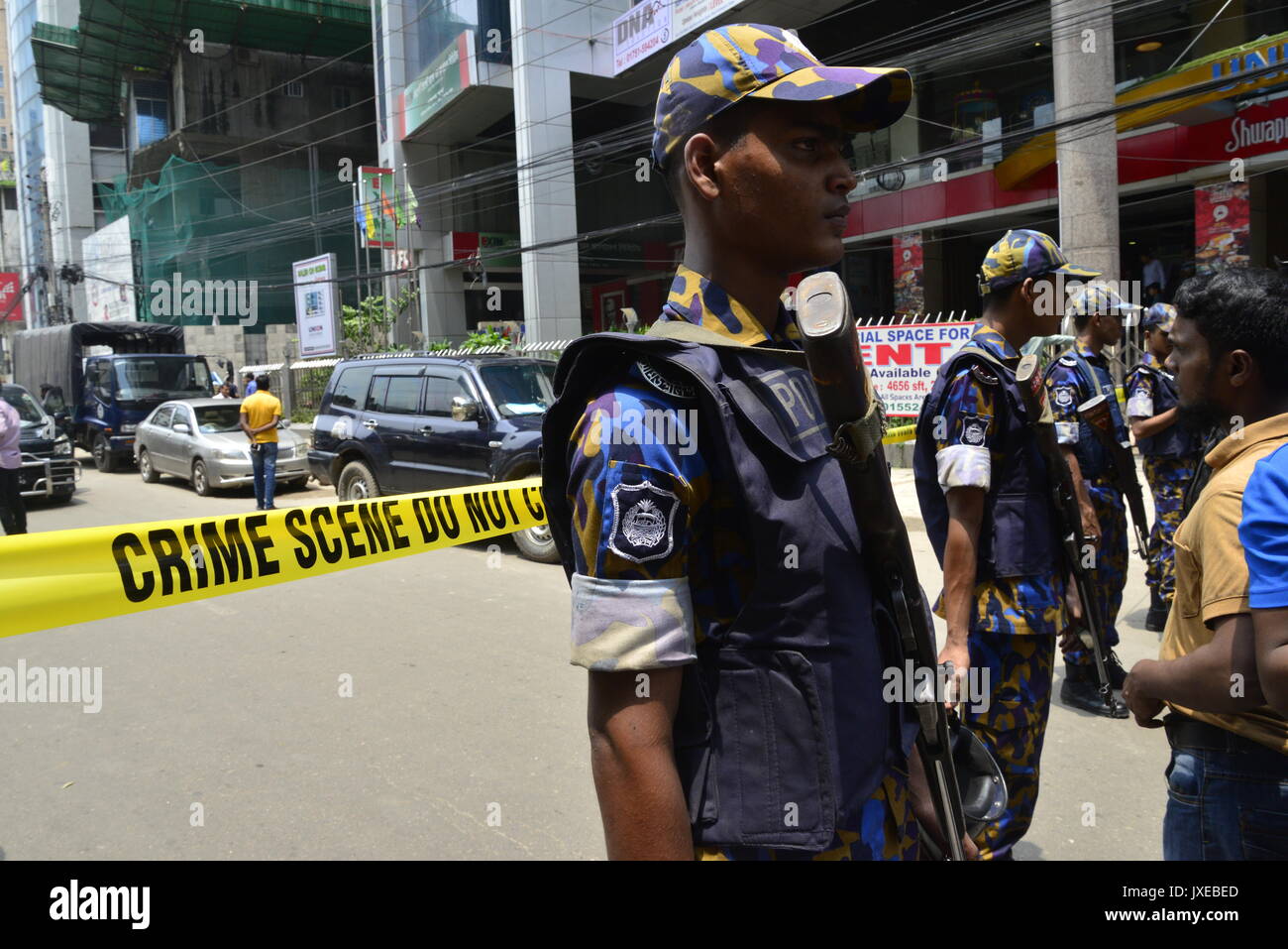 Dacca in Bangladesh. Il 15 agosto, 2017. Bangladesh dei funzionari di polizia guardia come gli astanti si riuniranno presso la scena di una operazione di tempesta un presunto nascondiglio militante a Dhaka il 15 agosto 2017. Un sospetto militante è stato ucciso in un'operazione in un albergo a Dhaka Panthapath dell area dove lawmen hanno condotto un raid sospettare un militante nascondiglio questa mattina presso l'Hotel Olio International a Dhaka, nel Bangladesh. Credito: Mamunur Rashid/Alamy Live News Foto Stock