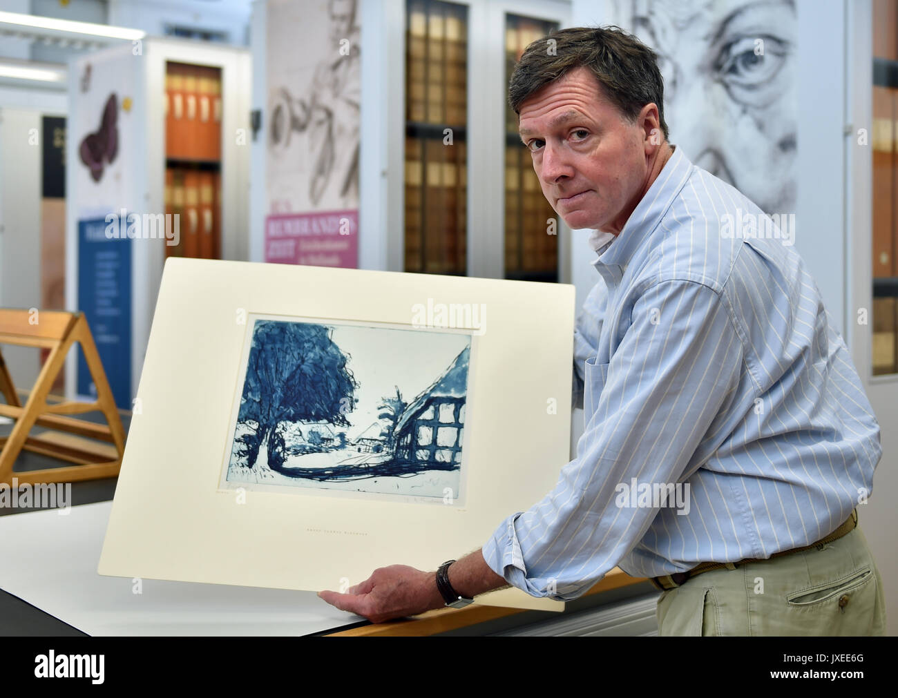 Berlino, Germania. Il 15 agosto, 2017. Il vice direttore del Kupferstichkabinet Berlino (Museo di stampe e disegni), Holm Bevers, detiene l'attacco 'Fehmarnhäuser mit großem Baum" (1908) (lit. Fehmarn case con il grande albero) dall artista Ernst Ludwig Kirchner nelle sue mani a Berlino, Germania, 15 agosto 2017. Ora, la Prussia Patrimonio Culturale Foundation ha acquistato il blu stampa di prova di un attacco dopo il ritorno agli eredi del collettore ebraica Eugen Moritz Buchtal. Foto: Britta Pedersen/dpa-Zentralbild/dpa/Alamy Live News Foto Stock