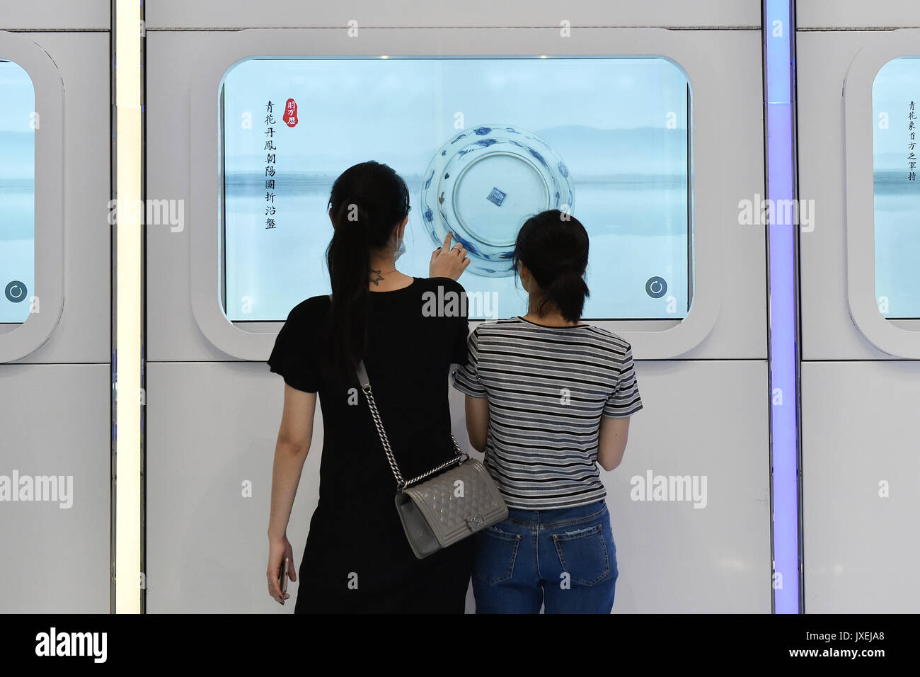 (170816) -- GUANGZHOU, Agosto 16, 2017 (Xinhua) -- i visitatori esperienza un touch screen visualizzati al corridoio culturale nell'Aeroporto Internazionale di Baiyun di Guangzhou, la capitale del sud della Cina di Provincia di Guangdong, Agosto 16, 2017. Guangzhou Baiyun International Airport, insieme con il museo provinciale, terrà una manifestazione pubblica a tema il Maritime Silk Road, il primo presso lo storico corridoio culturale che ha inaugurato ufficialmente qui mercoledì. (Xinhua/Liang Xu)(wjq) Foto Stock