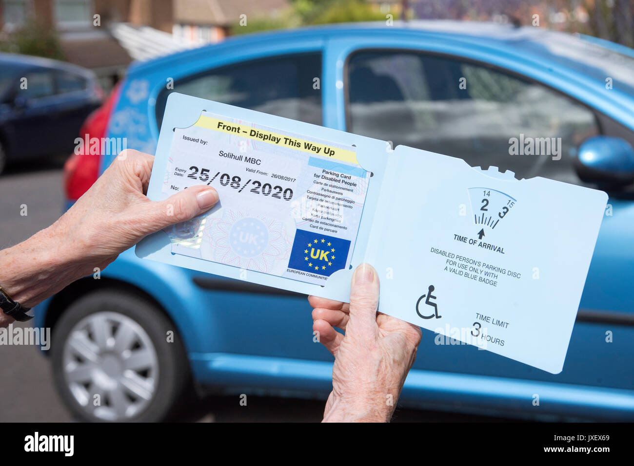 Donna di mani Blue Badge disco di parcheggio rilasciati nel Regno Unito per i guidatori disabili Foto Stock