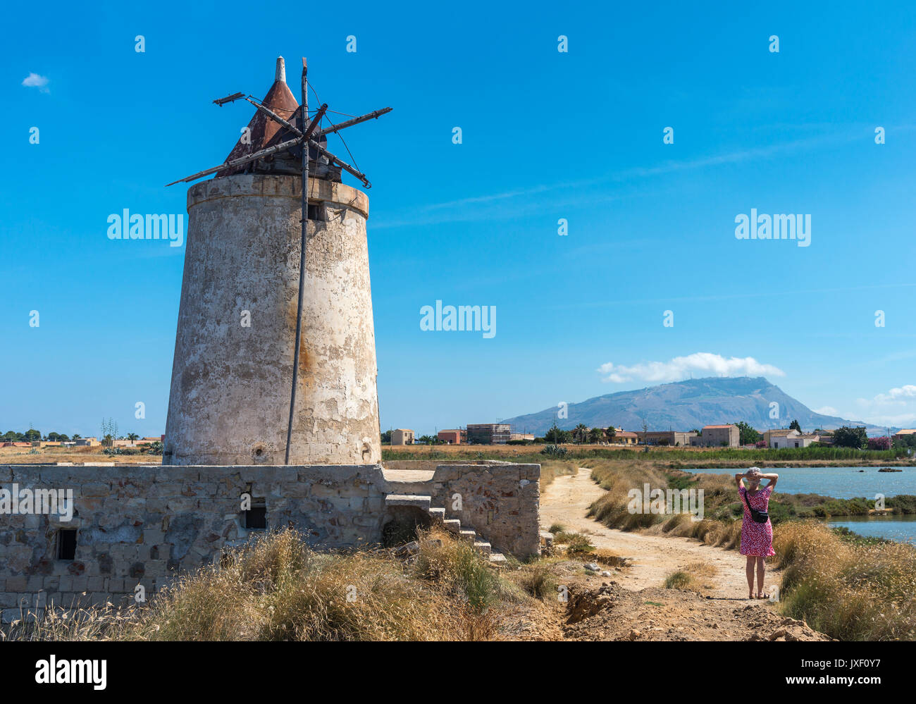 Saline e mulino a vento abbandonati alla Salina grande riserva naturale vicino Culcasi, a sud di Trapani, sulla costa occidentale della Sicilia, Italia. Foto Stock