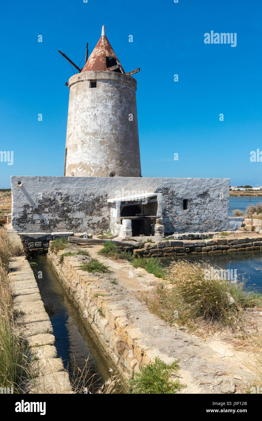 Saline e mulino a vento abbandonati alla Salina grande riserva naturale vicino Culcasi, a sud di Trapani, sulla costa occidentale della Sicilia, Italia. Foto Stock