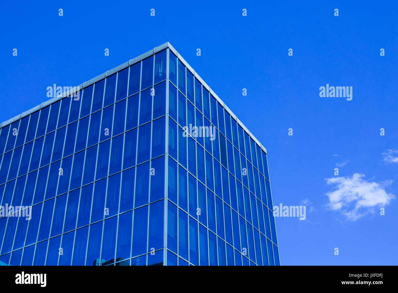 Uffici moderni edifici in città con la riflessione di altro edificio in blu le finestre in vetro e la parete di vetro ,con nuvole bianche Foto Stock