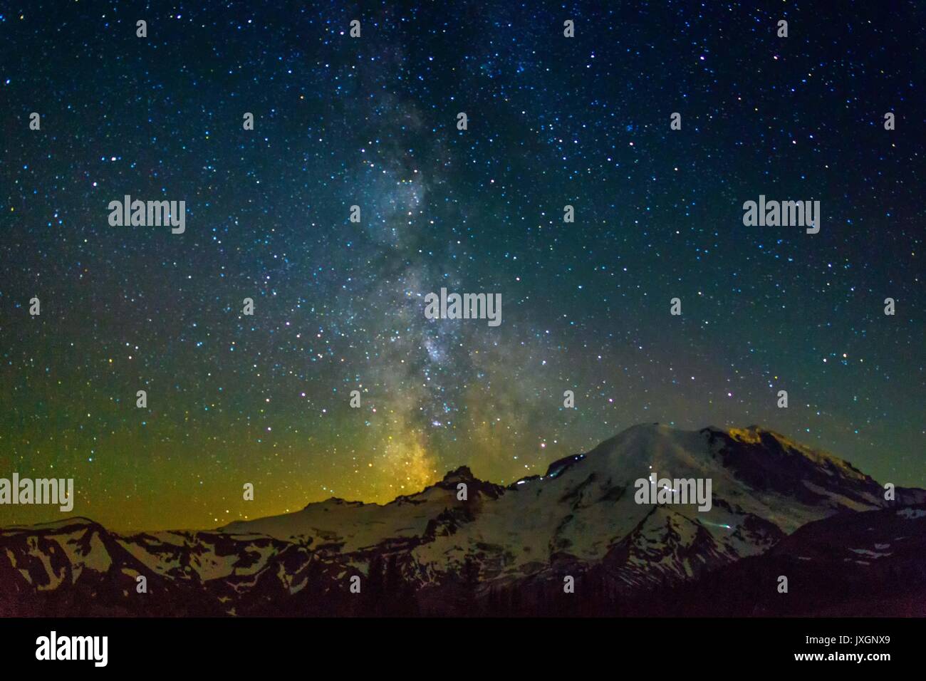 La Via Lattea su Mt. Ranier. Le luci sulla montagna sono gli scalatori lavorando il loro modo per il vertice. Guardare le luci più grandi in quanto di un 30 seconda esposizione. Foto Stock