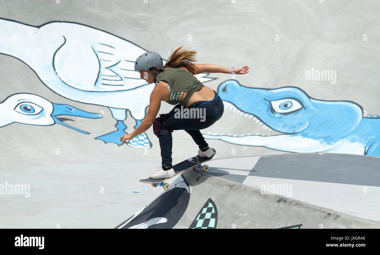 Guidatore di skateboard femmina sembra essere la fuga da un alligatore Foto Stock