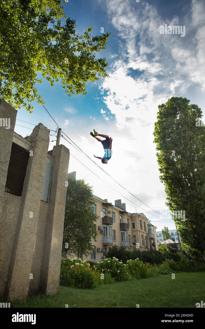 Città parkour. Il ragazzo non il contrario somersault. Scattare da un angolo basso. Agilità, adrenalina e extreme. Foto Stock