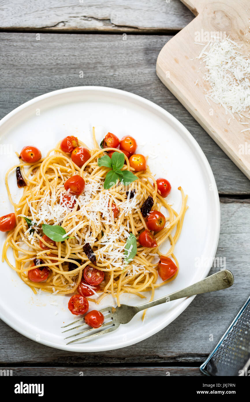 Spaghetti con pomodorini e peperoncino essiccato con parmigiano grattugiato Foto Stock