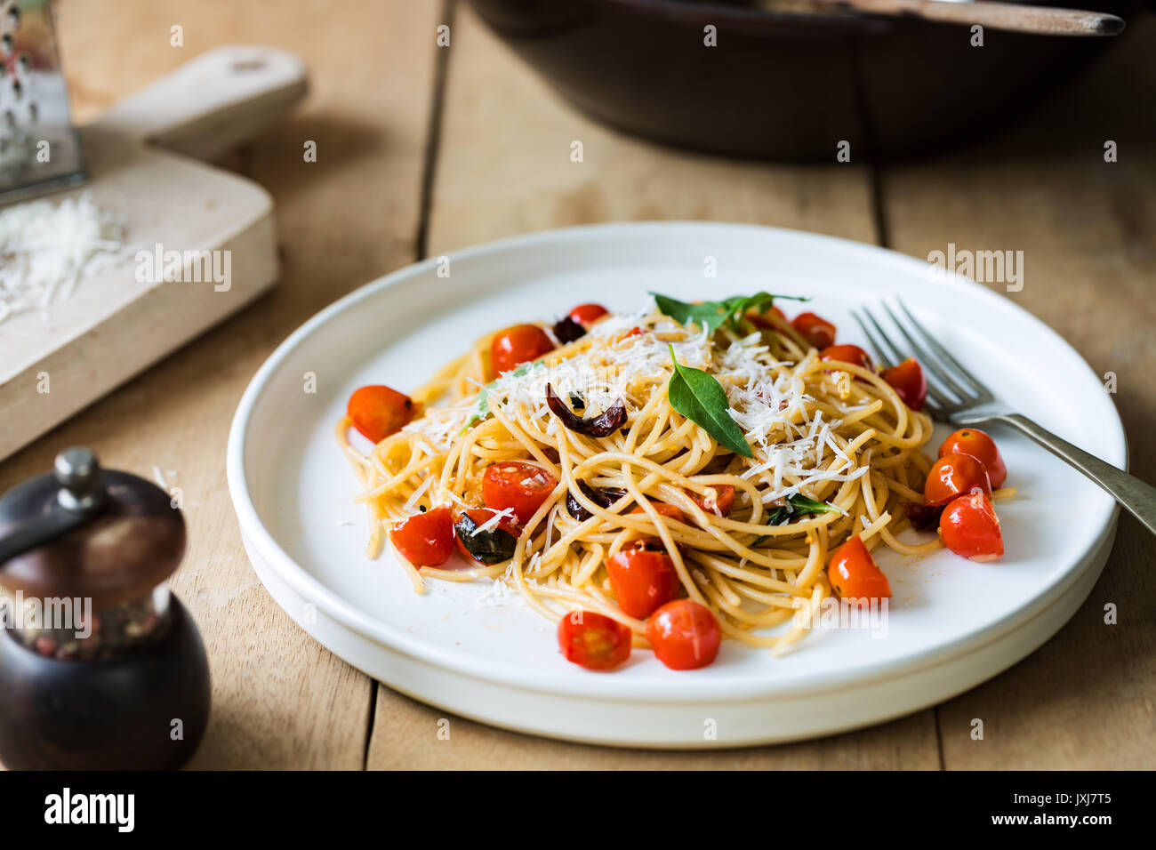 Spaghetti con pomodorini e peperoncino essiccato con parmigiano grattugiato Foto Stock
