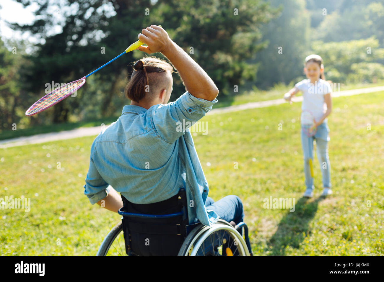 A MOBILITÀ RIDOTTA uomo passando volano alla figlia Foto Stock