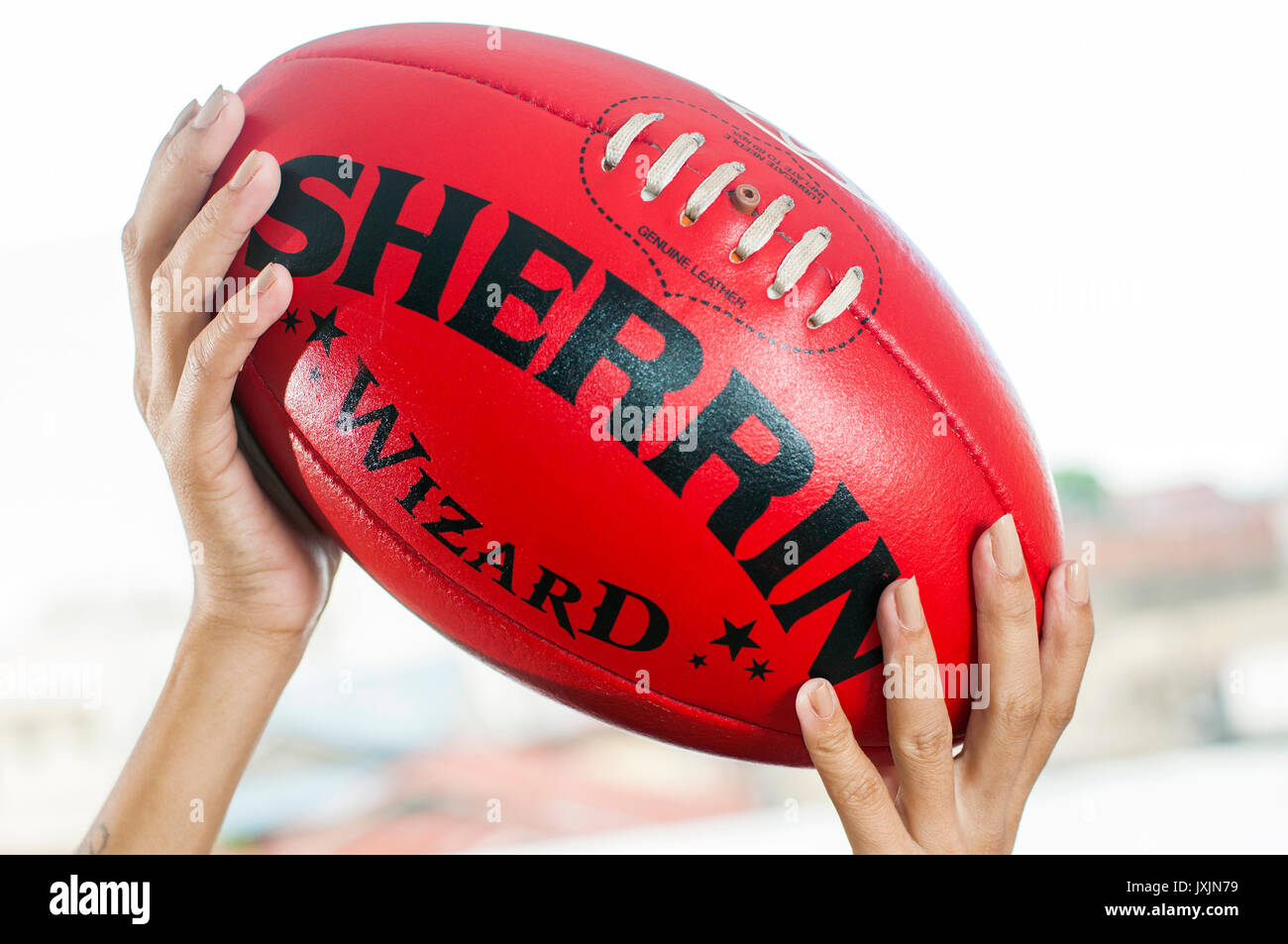 Giovane donna asiatica azienda Australiana AFL Football Foto Stock