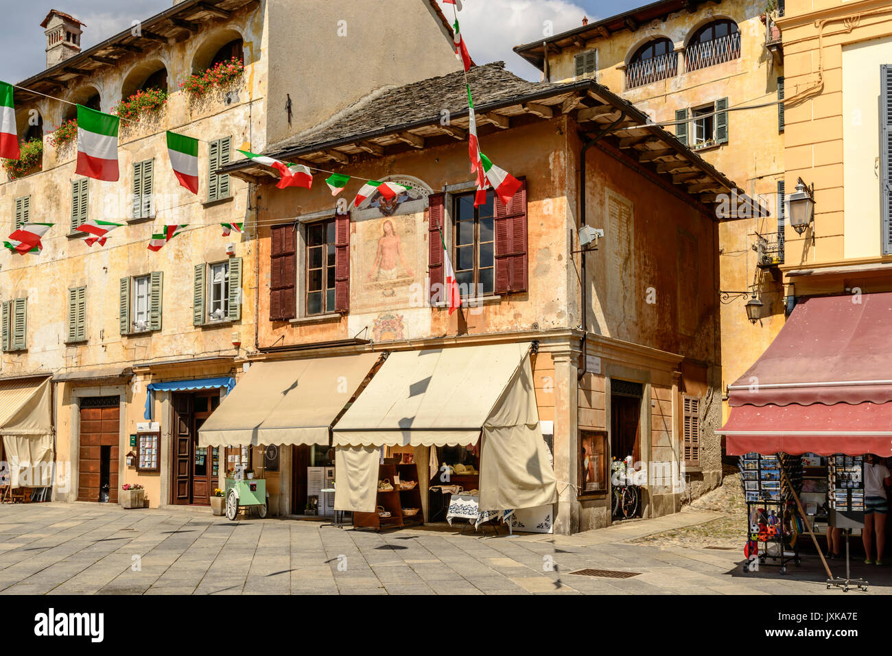 Il vecchio edificio pittoresco sulla piazza Motta a storico villaggio turistico, shot sulla luminosa giornata estiva a Orta San Giulio, Novara, Cusio, Italia Foto Stock