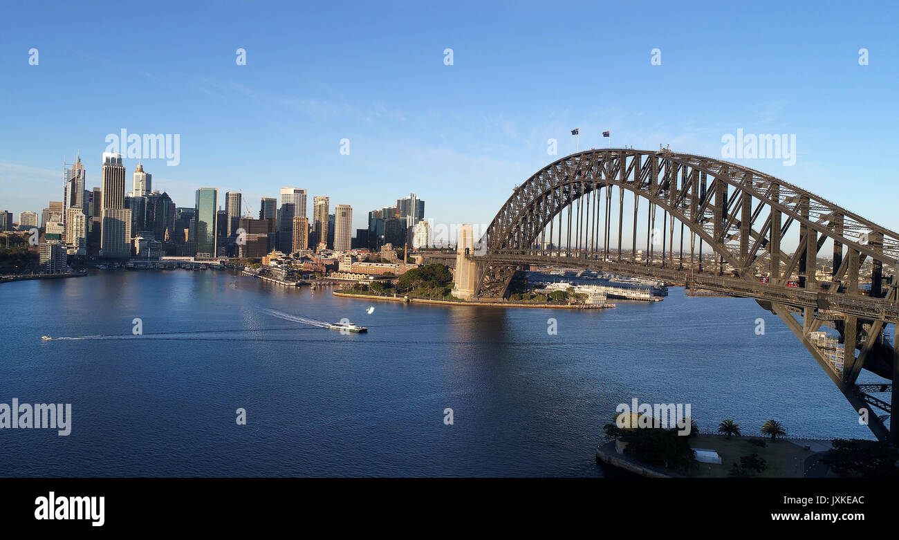 Antenna ampia vista sul porto di Sydney al di sopra di arcata del ponte del Porto verso le rocce , Circular Quay e il CBD alti torri. Foto Stock