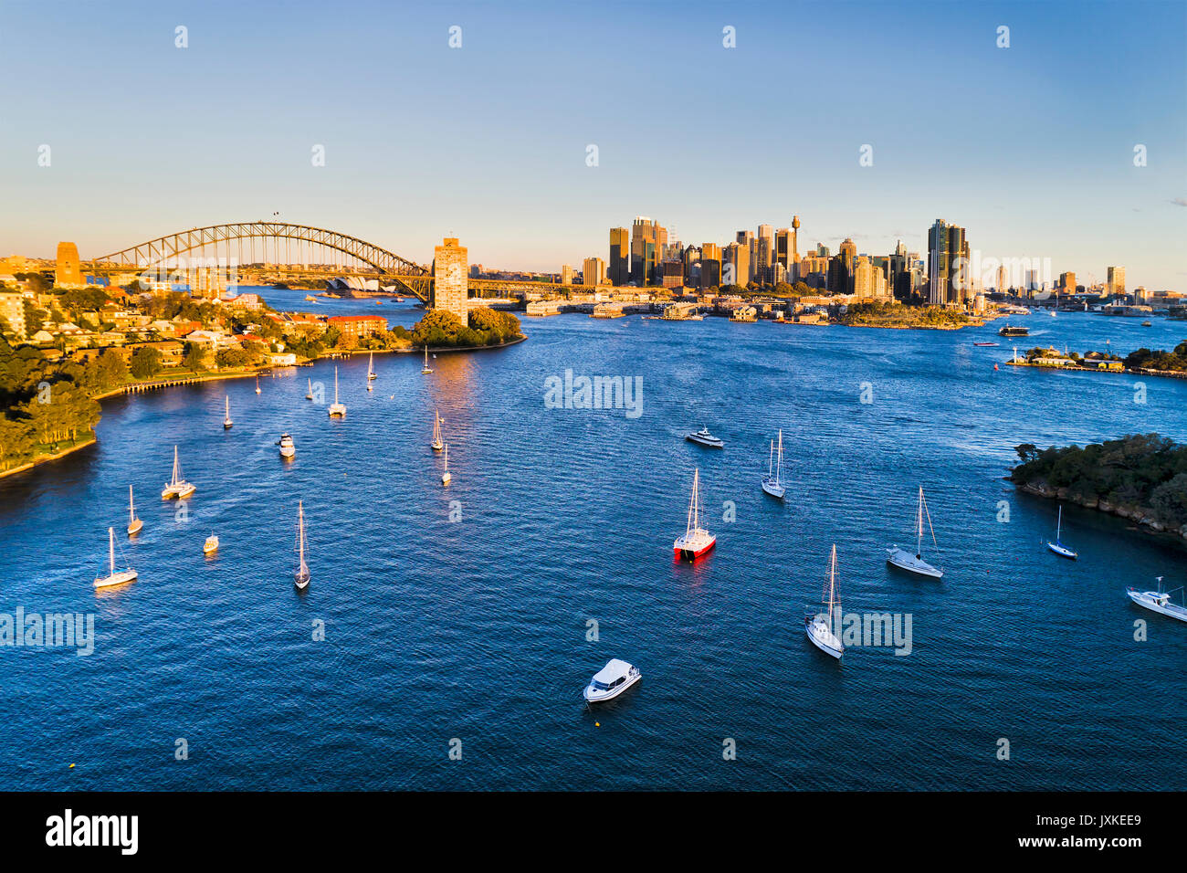 Antenna fuco vista della città di Sydney CBD, Harbour Bridge e il porto al di sopra della baia di frutti di bosco al tramonto. Attraccata yacht privati in sfere di riserva di testa e alto- Foto Stock