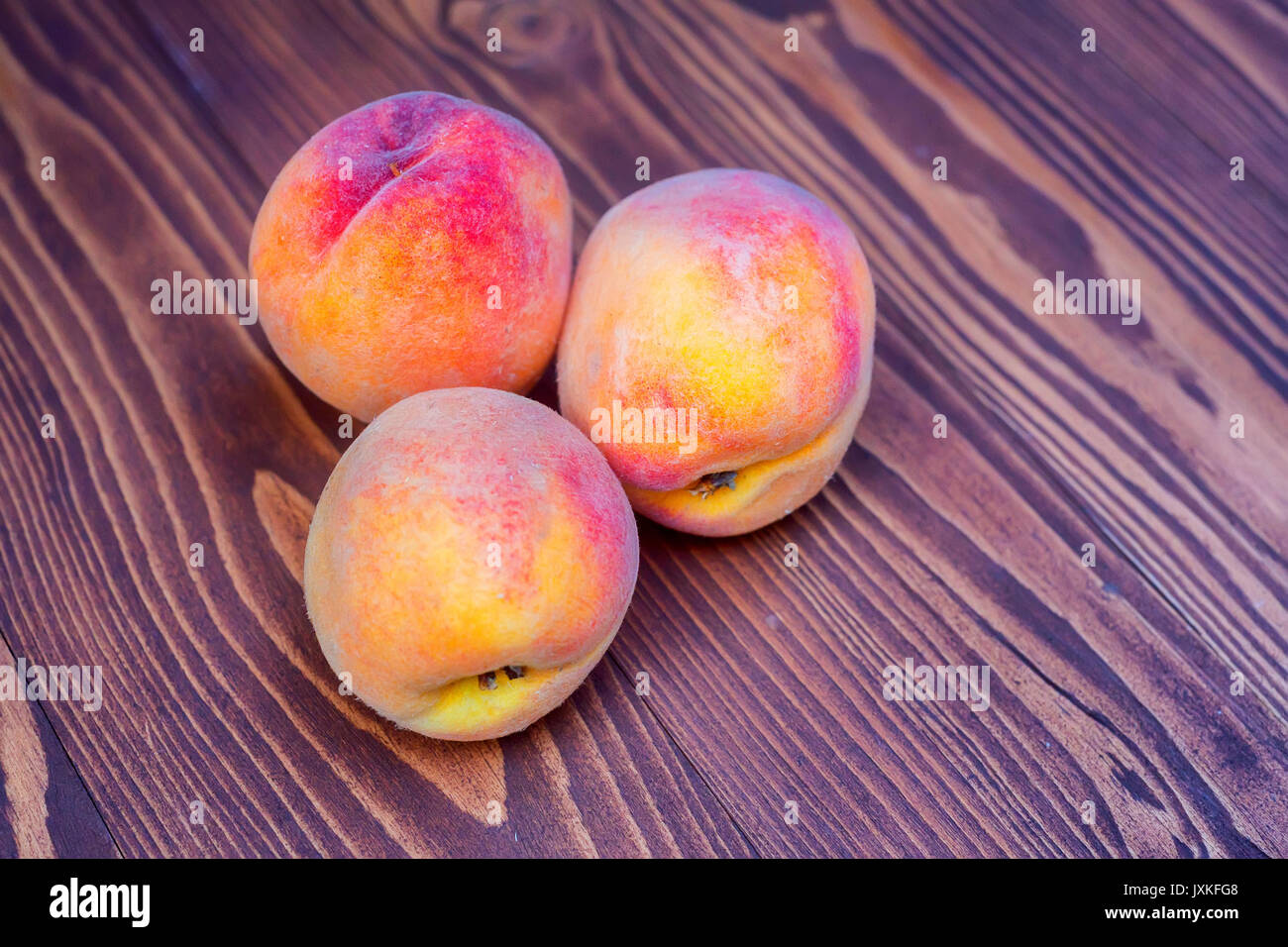 Succose pesche su sfondo di legno Foto Stock