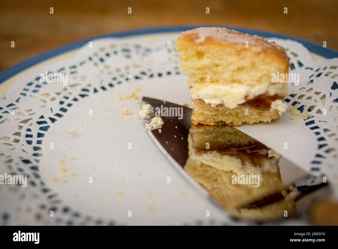 L'ultima fetta di marmellata e crema pan di spagna su un carrello della carta Foto Stock