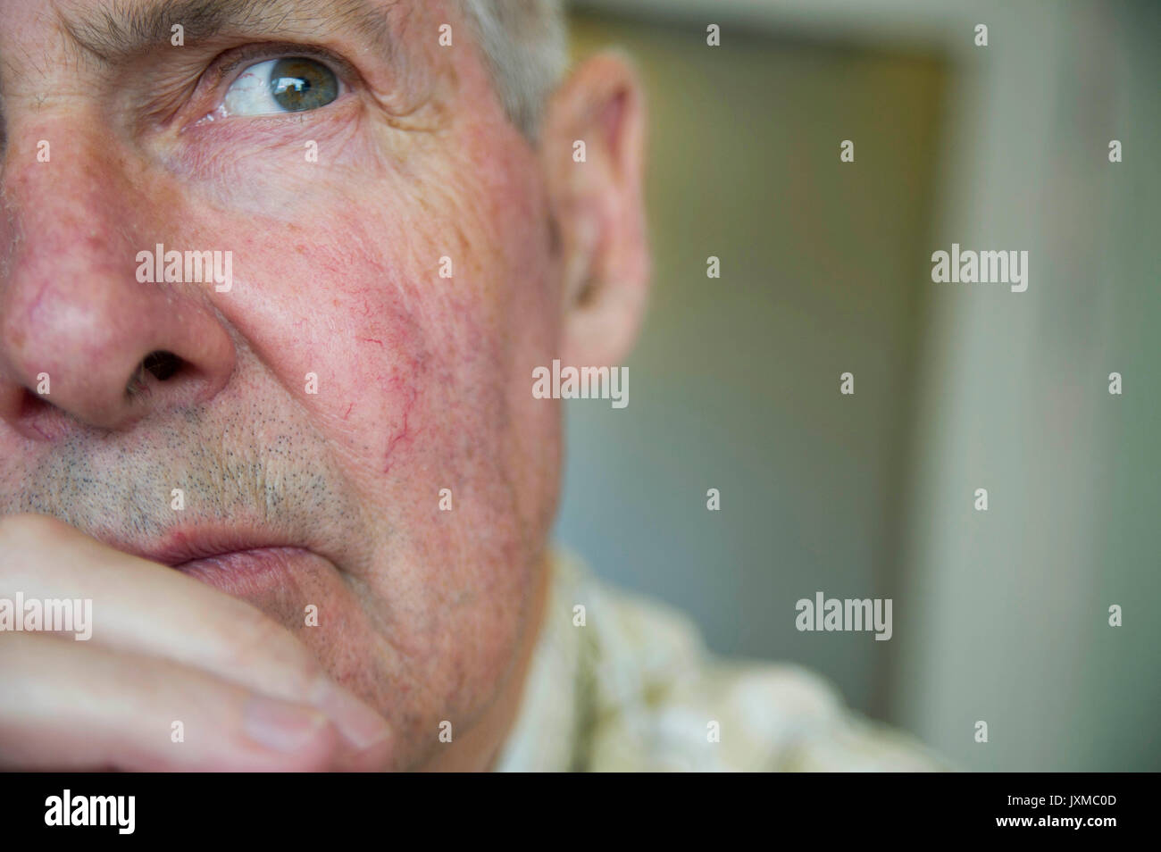 Uomo anziano medita la vita mentre staring a distanza Foto Stock