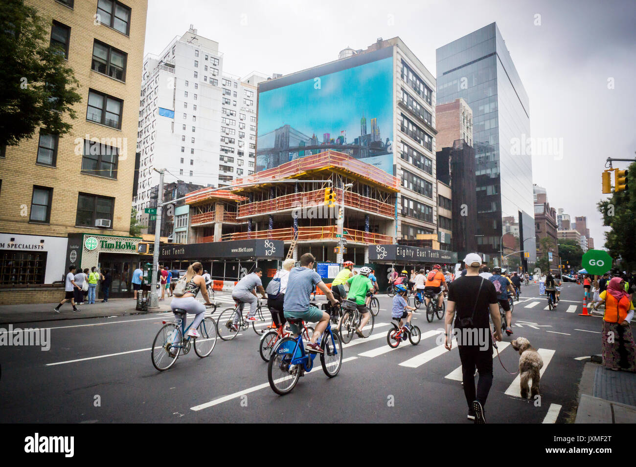 Biciclette e pedoni per strada il passaggio di sviluppo nel East Village il Sabato, 12 agosto 2017 per l'annuale New York Estate strade evento. 6.9 miglia di strade di Manhattan sono stati liquidati di traffico dalle 7 a.m. alle 1 P.M., stretching dal ponte di Brooklyn a Oriente 72street e migliaia di persone sono venute a piedi, in bicicletta e a lasciarsi coinvolgere in attività che sono state impostate in corrispondenza del resto si ferma lungo la strada. (© Richard B. Levine) Foto Stock