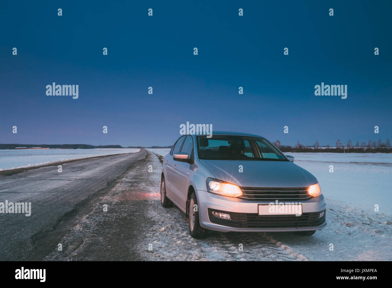 Berlina auto il parcheggio su strada di strada di campagna su uno sfondo di cielo blu alla stagione invernale. Foto Stock