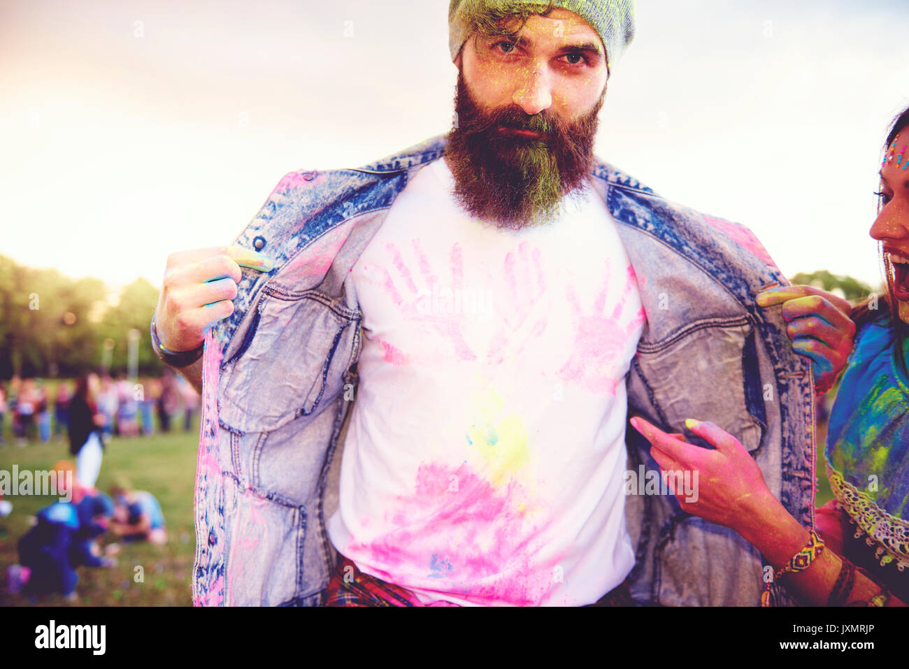 Ritratto di giovane maschio hipster con chalk handprints su tshirt al festival Foto Stock