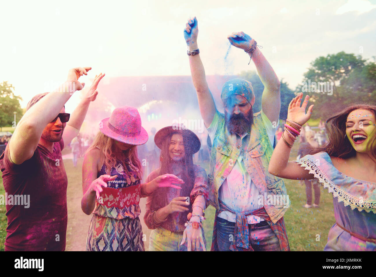Giovani amici adulti dancing e gettando colorato polvere di gesso al festival Foto Stock