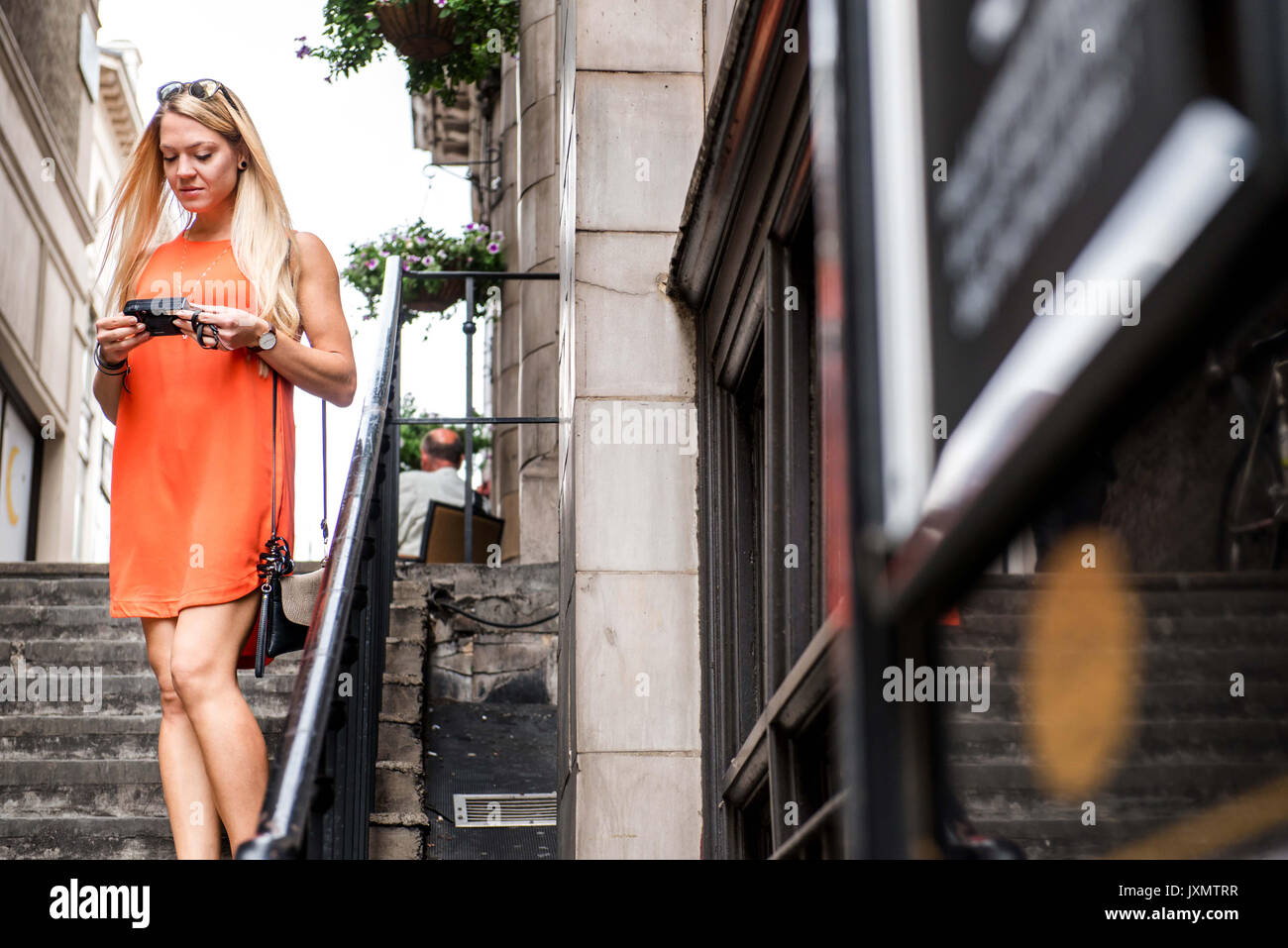 Turista femminile a Londra, osservando le immagini sullo schermo della fotocamera Foto Stock