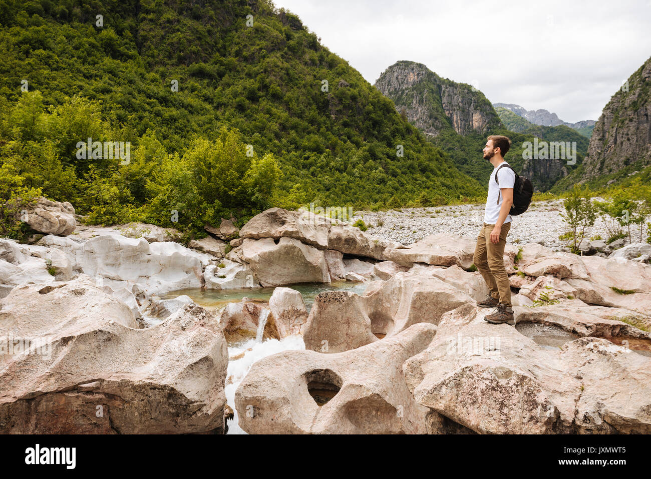 Uomo in piedi sulle rocce che guarda lontano, maledetto montagne, Theth, Scutari, Albania, Europa Foto Stock