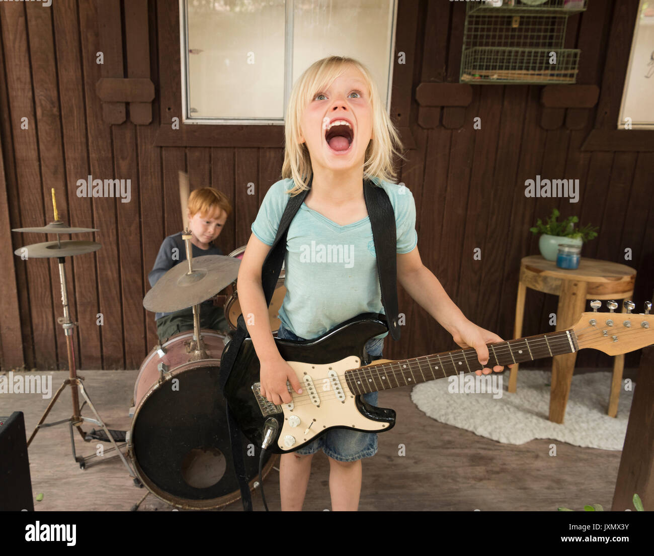 I bambini a suonare la chitarra e percussioni in banda Foto Stock